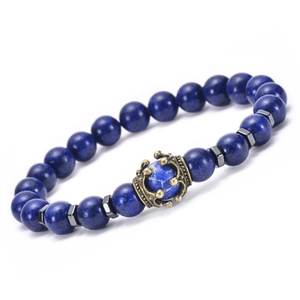 Macro shot of blue beaded bracelet with gold crown charm and black hexagonal spacers