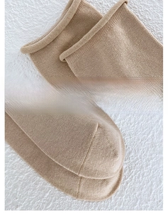 Macro shot of elastic rolled cuff and reinforced toe of a tan ribbed knit cotton sock