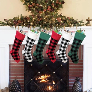 Classic knitted plaid Christmas stockings hanging over fireplace with warm holiday lights