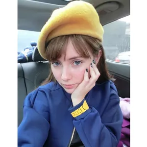 Stylish yellow knit beret hat for women worn in a casual indoor setting