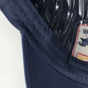 Close-up of navy blue washed cotton cap showing detailed multi-row stitching and embroidery