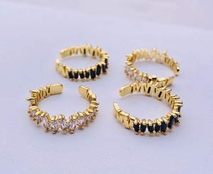 Close-up of adjustable gold rings with baguette-cut black and white cubic zirconia