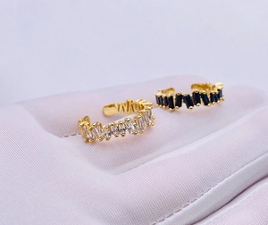 Macro view of adjustable gold-plated C-rings with baguette-cut white and black crystals