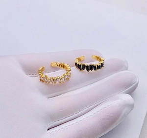 Detailed macro view of adjustable gold-plated rings with black and white zircon crystals