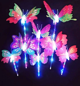 Close-up of LED glowing butterfly wands with vibrant colorful plastic wings in dark setting