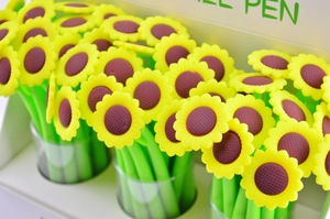 Macro shot of cartoon sunflower gel pens with yellow petals and green stem-like bodies