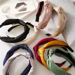 Top view of knotted satin headbands in nine various colors with silky texture and sheen
