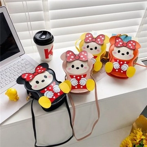 Detail showing four colorful cartoon mini crossbody bags in black, pink, yellow and red