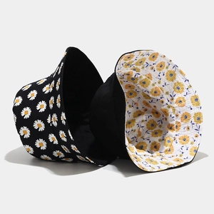 Close-up of double-sided bucket hat with daisy print and floral pattern on white background