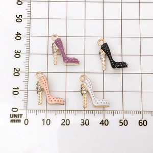 Größenmessung von vier Emaille-High-Heel-Anhängern mit Strasssteinen auf Rasterhintergrund