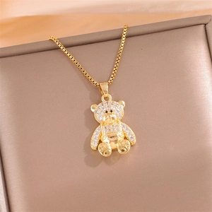 Golden bear pendant necklace with sparkling clear zircons on a jewelry box lid