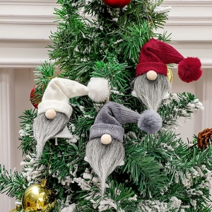 Three festive Christmas gnome bells in red, white, and grey hanging on a decorated tree