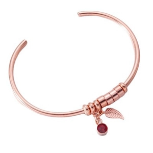 Rose gold C-shaped open bangle with red gemstone and leaf pendant charms on white background