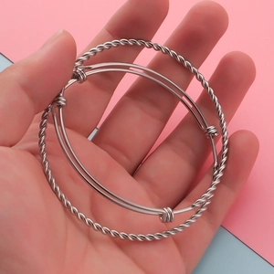 Close-up of twisted rope and smooth adjustable stainless steel cuff bracelets