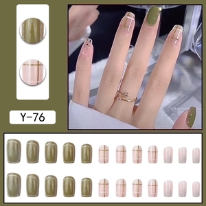Green and pink press-on nails with plaid patterns, gold glitter and French tip finish