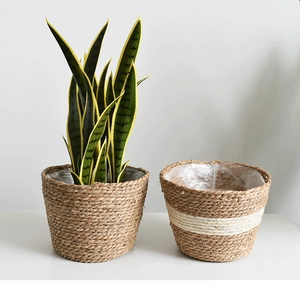 Detail of hand-woven straw flower pots showing natural texture and plastic lining
