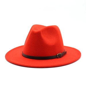 Detail of red wool felt fedora with black leather band and gold metal buckle