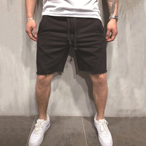 Detail of men's black sweat shorts with drawstring waist and raw edge hem finish