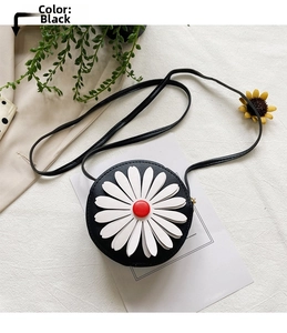Close-up of black crossbody bag for girls with white daisy flower detail and long strap