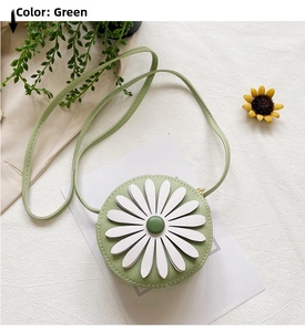 Detail of round green kids crossbody bag with 3D white daisy flower and thin strap