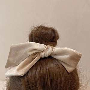Elegant beige velvet bow hair scrunchie shown on model for a vintage aesthetic style