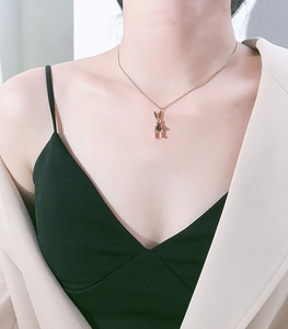 Detail of movable rabbit pendant in rose gold finish with black accents on a fine chain
