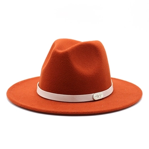 Detailed close-up of a caramel wool felt fedora with leather band and metal logo tag