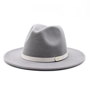 Detailed view of the gray wool fedora featuring a cream leather band and gold metal logo