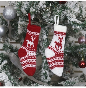 Détail de chaussettes de Noël tricotées avec motifs de rennes sur un sapin décoré