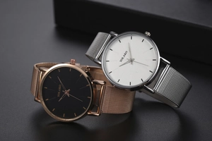 Close-up of minimalist quartz watches with mesh bands in rose gold and silver finishes