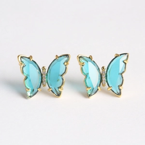 Detail of blue glass butterfly earrings with gold plating and sparkling zircon accents