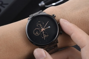 Close-up of Yolako chronograph watch with black dial and three sub-dials on a steel band