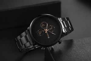 Macro view of black stainless steel watch dial with three subdials and calendar window