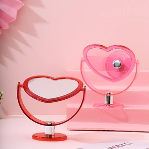 Close-up of heart-shaped desktop makeup mirrors in transparent red and pink acrylic