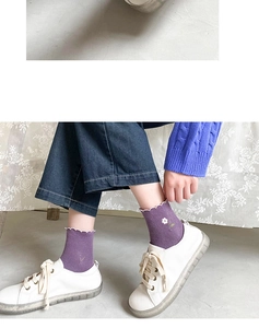 Close-up of purple cotton socks with white lettuce edge trim and small floral embroidery