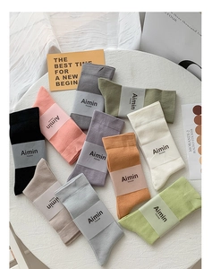 Flat lay of colorful mid-calf cotton socks in Morandi tones on a white surface