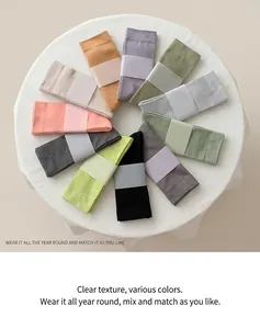 Flat lay of colorful Morandi style cotton crew socks set on white linen background