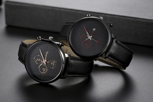 Detail of couple watches with black leather straps and rose gold and red accents