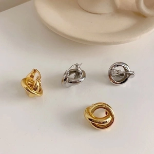 Elegant gold and silver interwoven metal hoop earrings on a minimalist white background