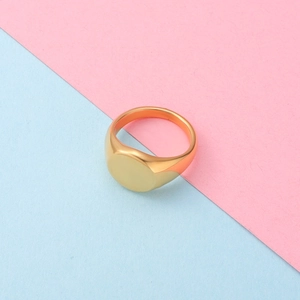 Detail of a minimalist gold-plated oval signet ring on a colorful textured background