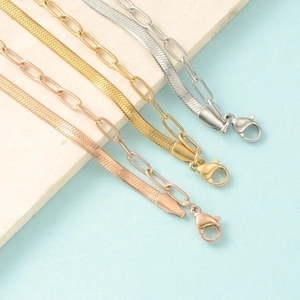 Detailed view of layered herringbone and paperclip chains in gold, silver, and rose gold finishes