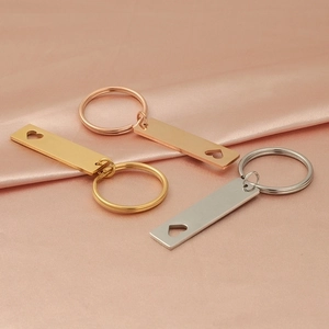 Three hollow heart rectangle keychains in gold, rose gold, and silver on silk fabric