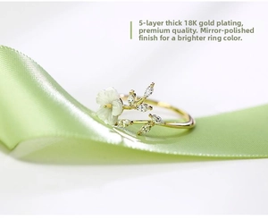 Macro shot of 18K gold plated ring with shell flower and zircon leaves on silk