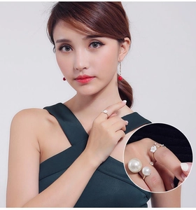 Detail of flower leaf ring with small pearls and large pearl ring on model's fingers