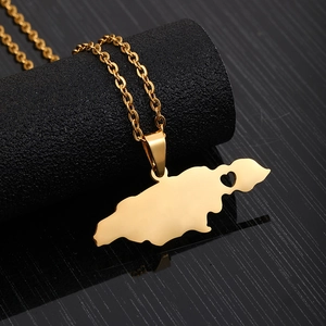 Close-up of golden Jamaica map pendant with heart cutout on black display stand
