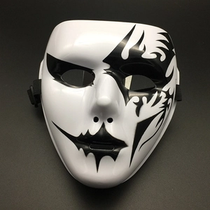 Macro shot of a white full-face Halloween mask with black tribal flame patterns and straps