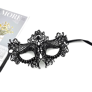 Detailed view of intricate black lace mask with silk ribbons for elegant masquerade party