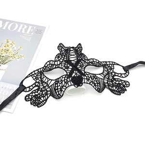 Macro shot of black lace cat-ear eye mask with delicate ribbons on white background