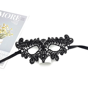 Detail of elegant black lace eye mask with intricate floral cutouts and satin ribbons
