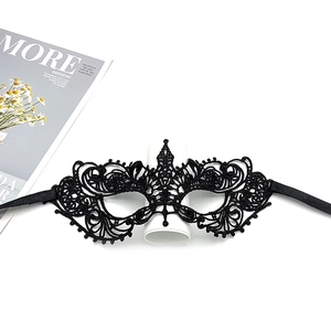 Flat lay of a black lace masquerade mask with intricate patterns and satin ribbons
